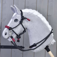 Siv Hobby Horse konj s spleteno belo grivo nosi vrvični komplet Maroon: črno vrvično oglavko in vajeti z bordo ovoji