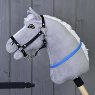 Siv plišast Hobby Horse konj z belo grivo in črno oglavko nosi živo moder vratni obroč (cordeo) okoli vratu