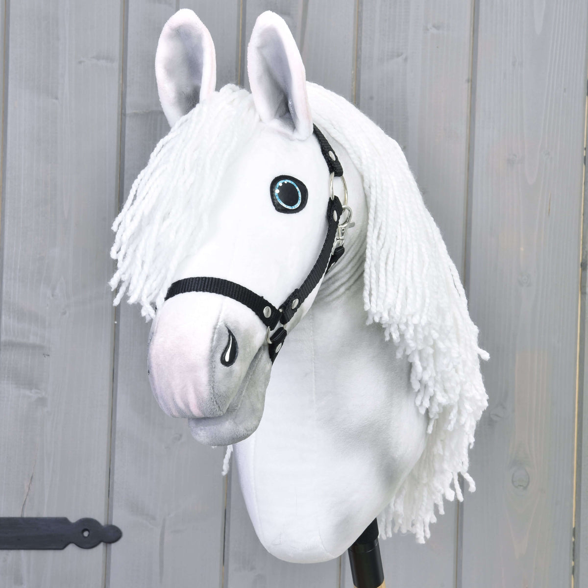 Hobby Horse konj Elektra s črno oglavko od spredaj, dolga bela griva iz preje pada na obe strani glave