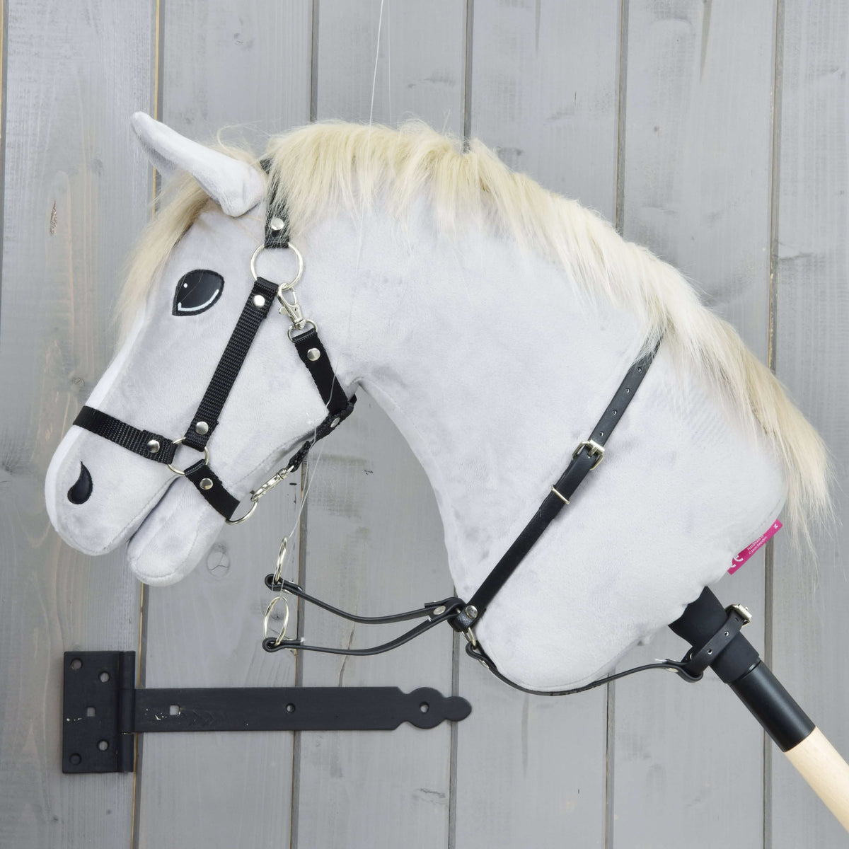Črn martingal na svetlo sivem Hobby Horse konju od strani, vratni jermen s sponko in dvema srebrnima obročkoma, ki visita spredaj