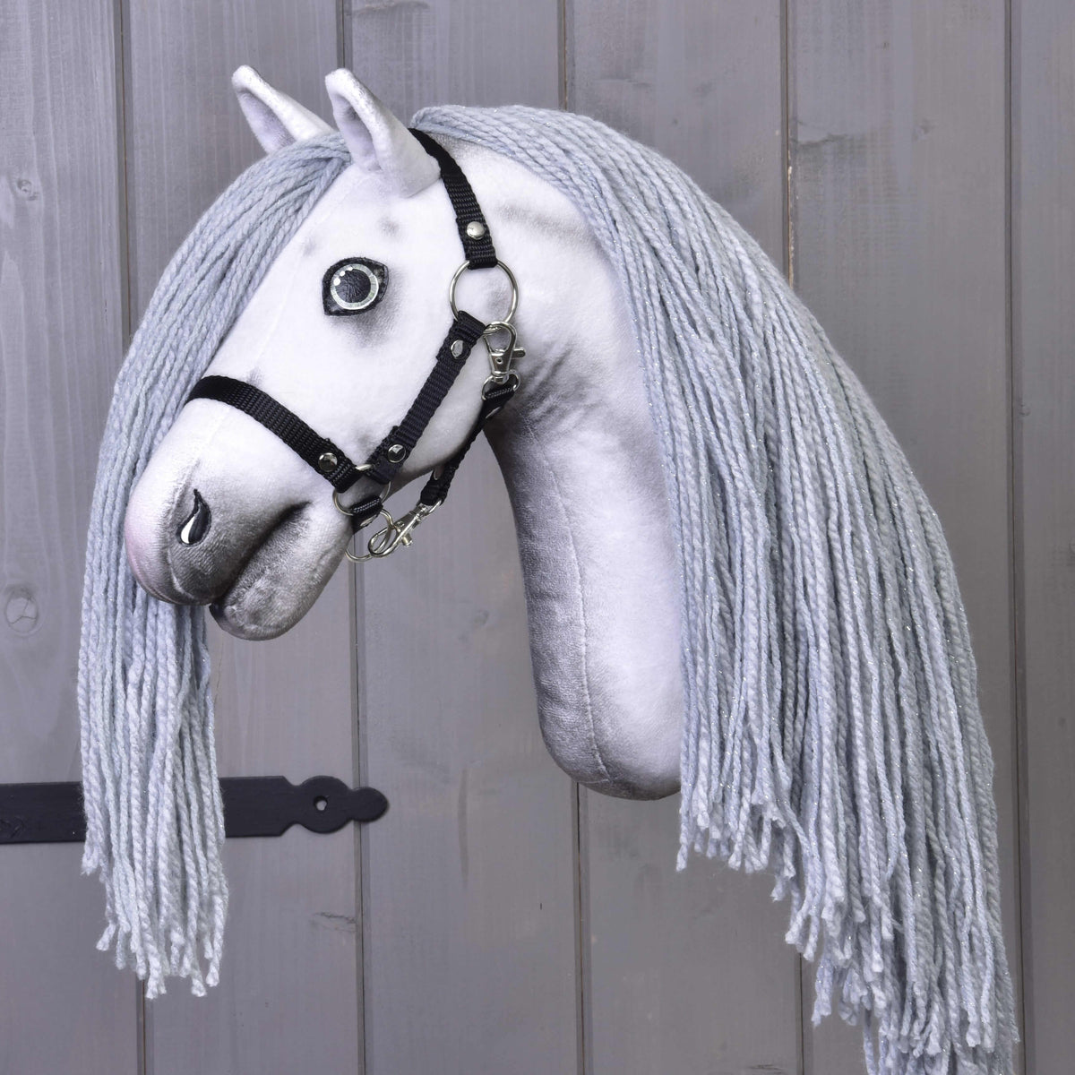 Tričetrtinski pogled na Hobby Horse samoroga Silver v črni oglavki: sivo senčenje na beli glavi in dolga siva griva