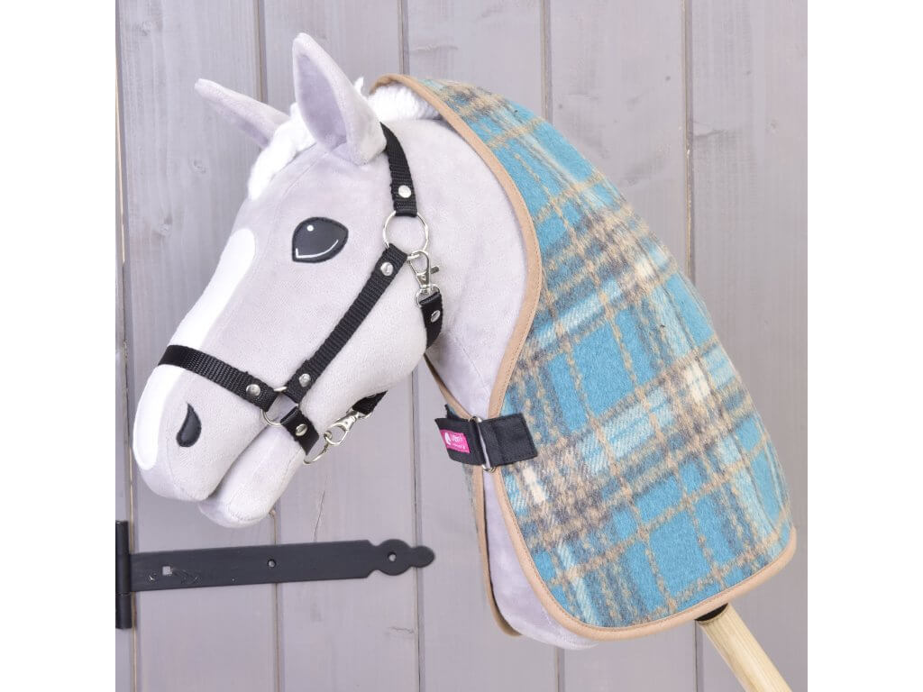 Siv Hobby Horse konj s črno oglavko, oblečen v modro karirasto hlevsko pregrinjalo čez vrat, zapeto s črnim trakom