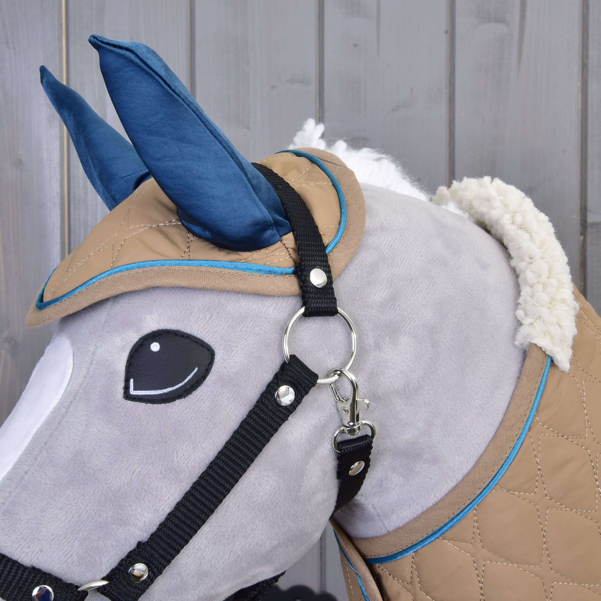 Glava sivega Hobby Horse konja od blizu z naušniki Almond Star, črno oglavko in puhastim ovratnikom pregrinjala iz umetnega ovčjega krzna