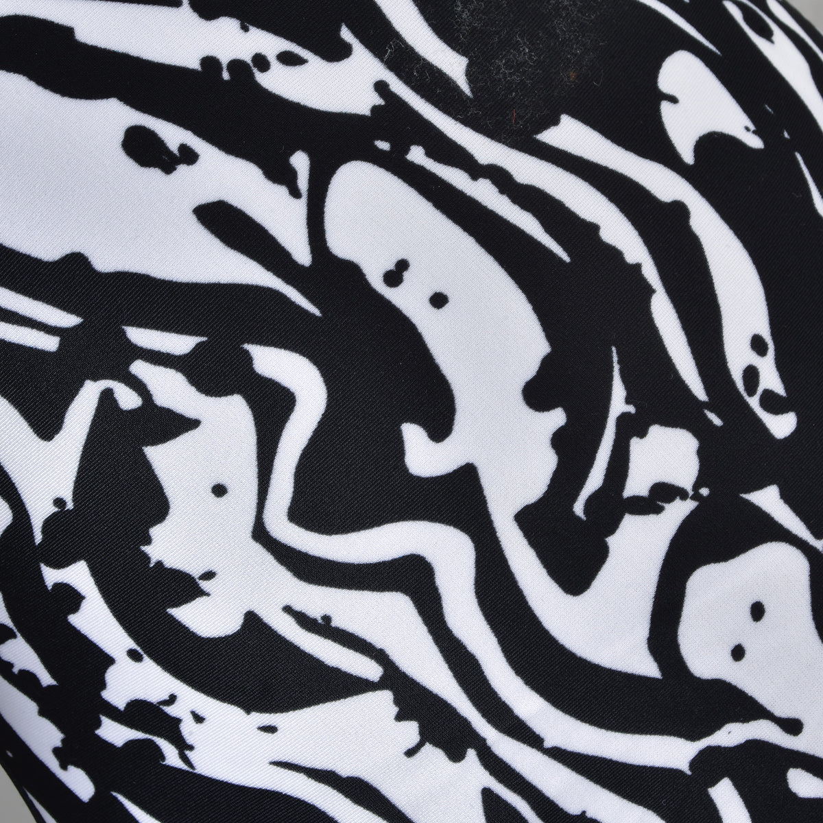 Close-up of the Black & White protective suit fabric with bold black and white swirls and ink-like splashes