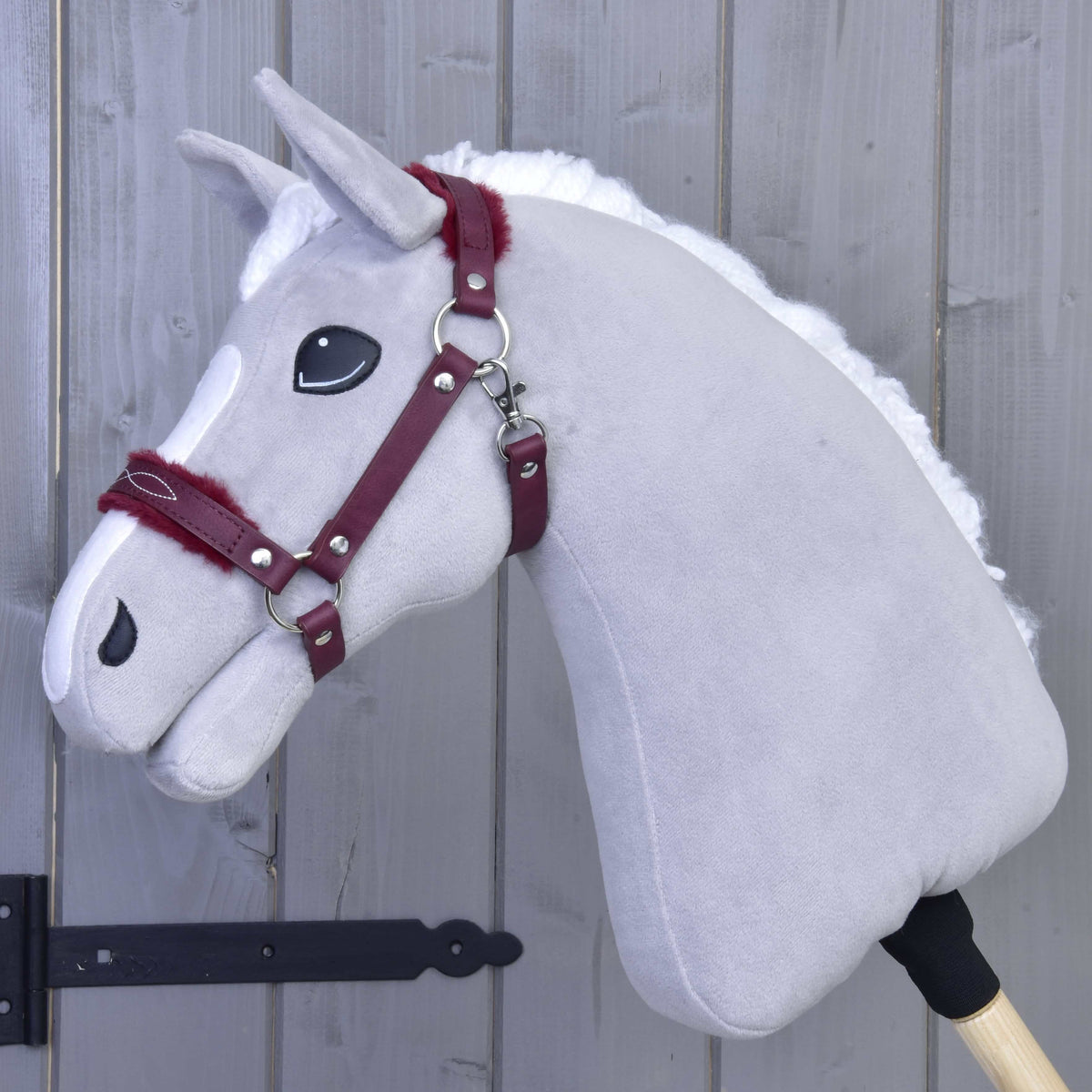 Svetlo siv Hobby Horse konj z belo grivo in bordo oglavko iz umetnega usnja s krznom na nosniku in zatilnem jermenu