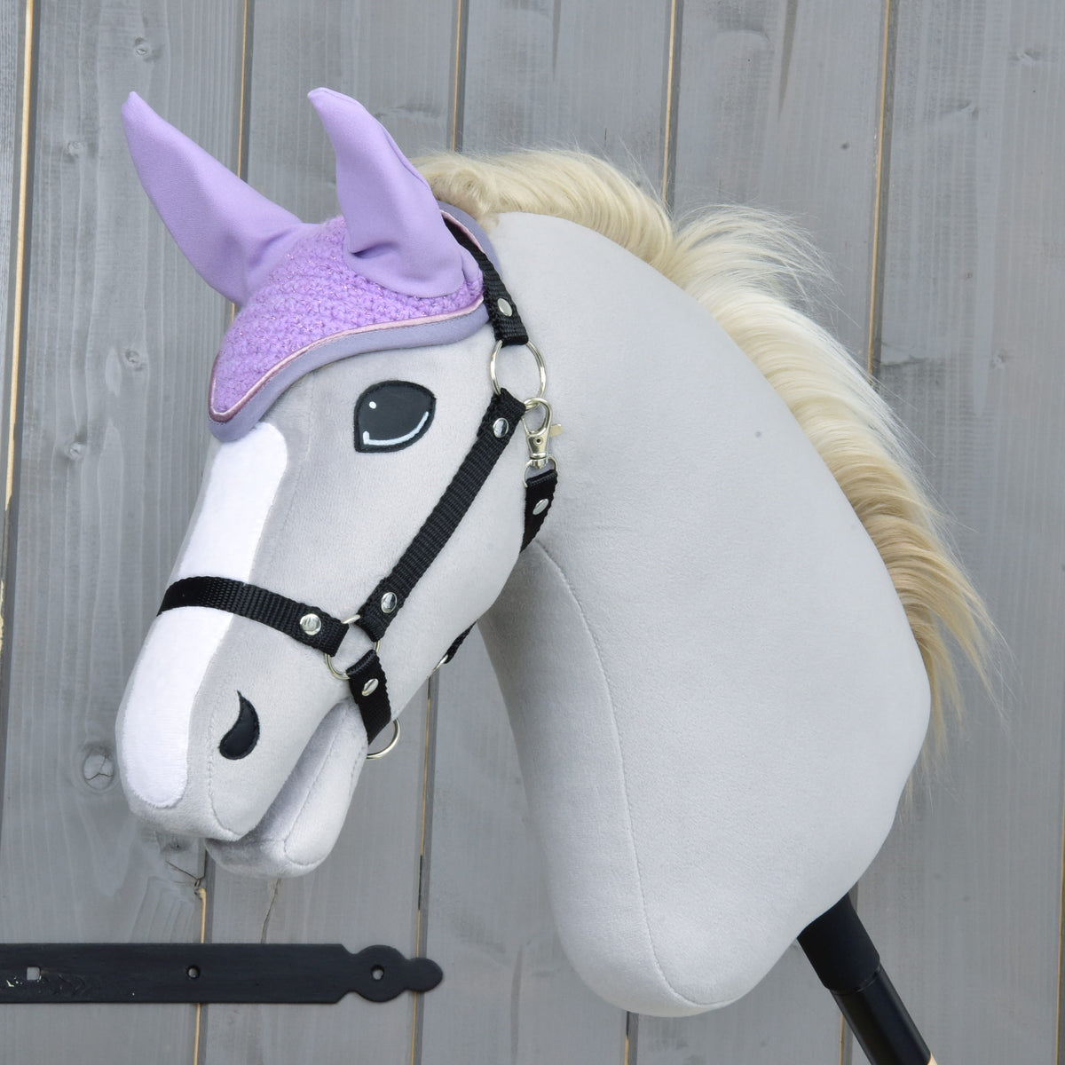 Light grey Hobby Horse with a black halter and cream mane wearing the lilac crocheted ear bonnet