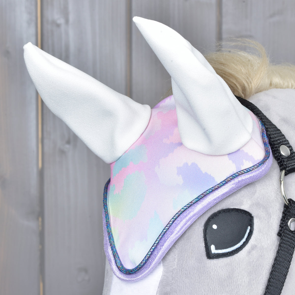 Close-up of the pastel ear bonnet on a grey Hobby Horse showing white ears and lilac edging with shimmering cord