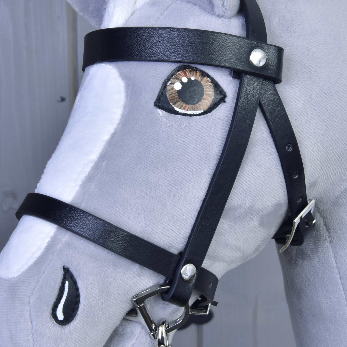 Close-up of the black Set Basic bridle on a grey Hobby Horse with browband, silver buckle and a brown eye