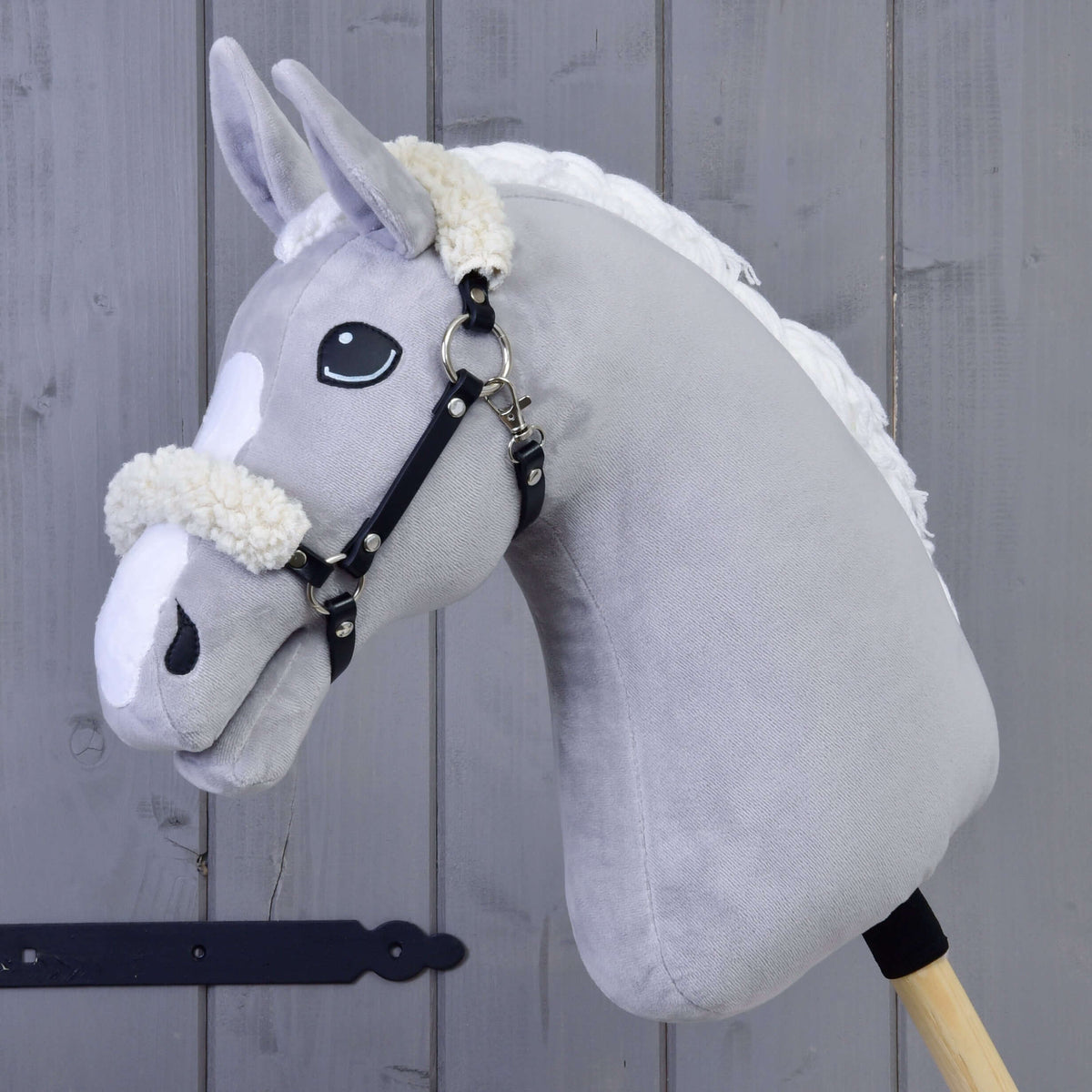 Grey Hobby Horse wearing the black leatherette halter with cream fur on the noseband and behind the ears