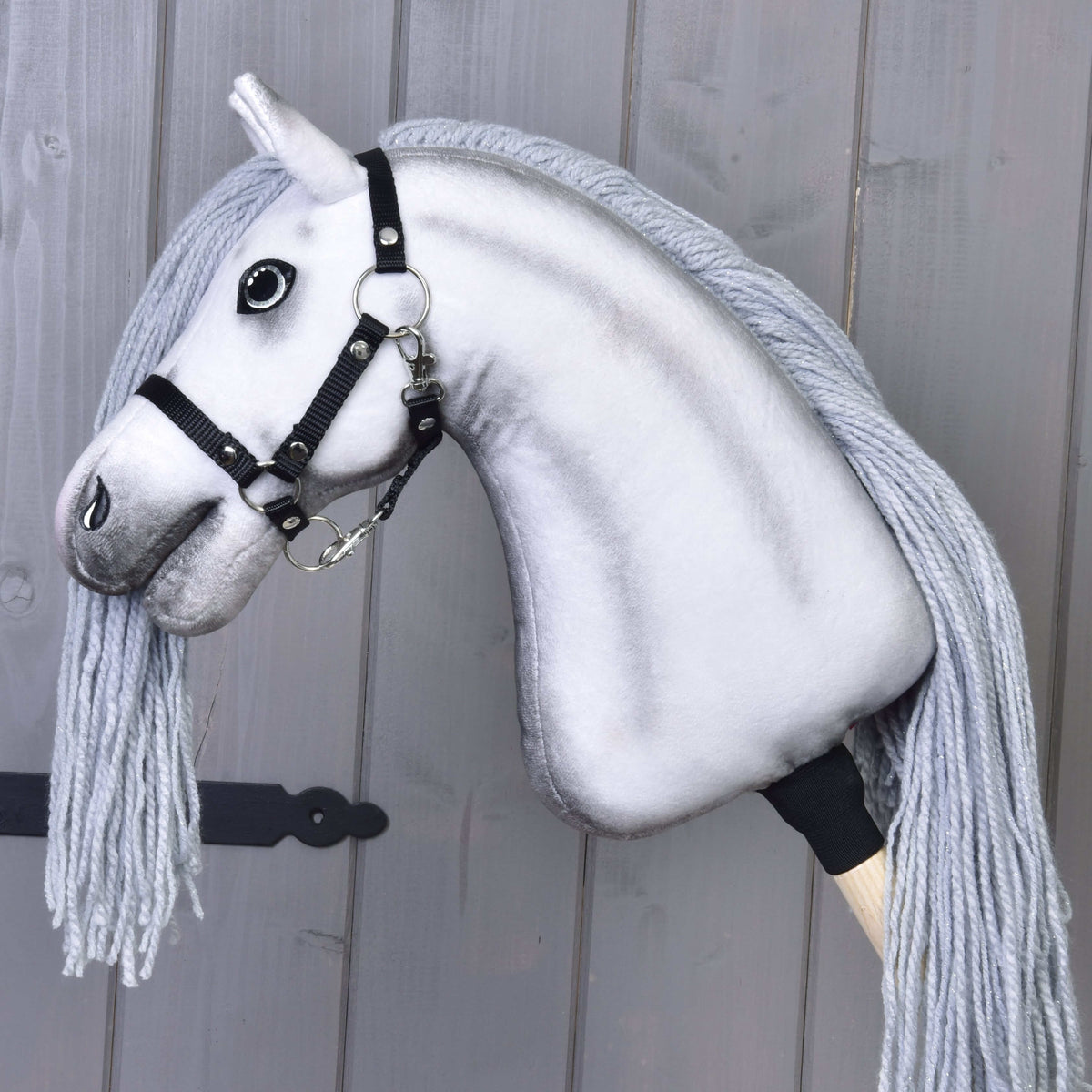 Hobby Horse samorog Silver v profilu s črno oglavko iz traku, sivo senčenim vratom, dolgo sivo grivo iz preje in palico