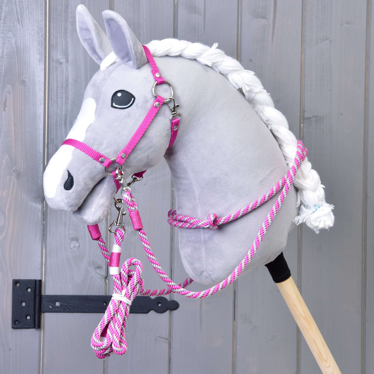 A grey plush Hobby Horse with a white blaze and braided mane wears the pink halter and rope reins of the Set Start Pink