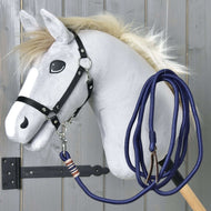 Siv Hobby Horse konj s črno oglavko in pripeto temno modro lonžo, ohlapno zvito čez vrat