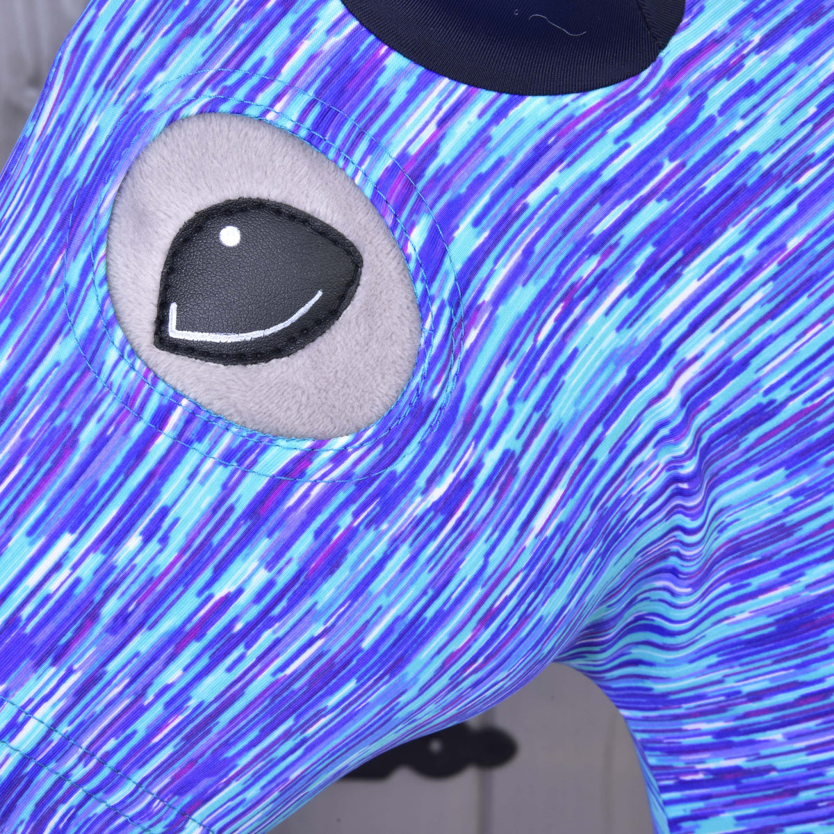 Close-up of the eye opening in the blue and purple streaked Lycra of the Sea protective suit on a Hobby Horse