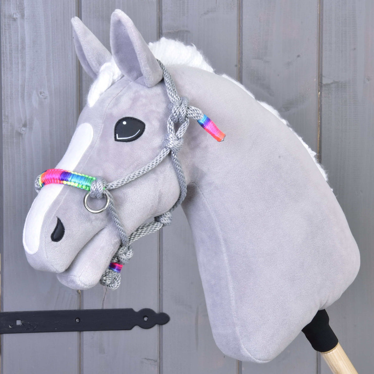 Grey plush Hobby Horse wearing the grey Manhattan rope halter with a bright rainbow noseband