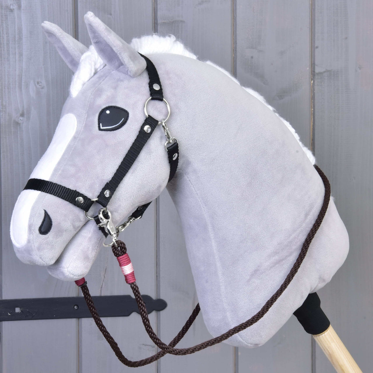 Siv plišast Hobby Horse konj s črno oglavko in temno rjavimi vrvičnimi vajetmi York z roza-bordo ovoji