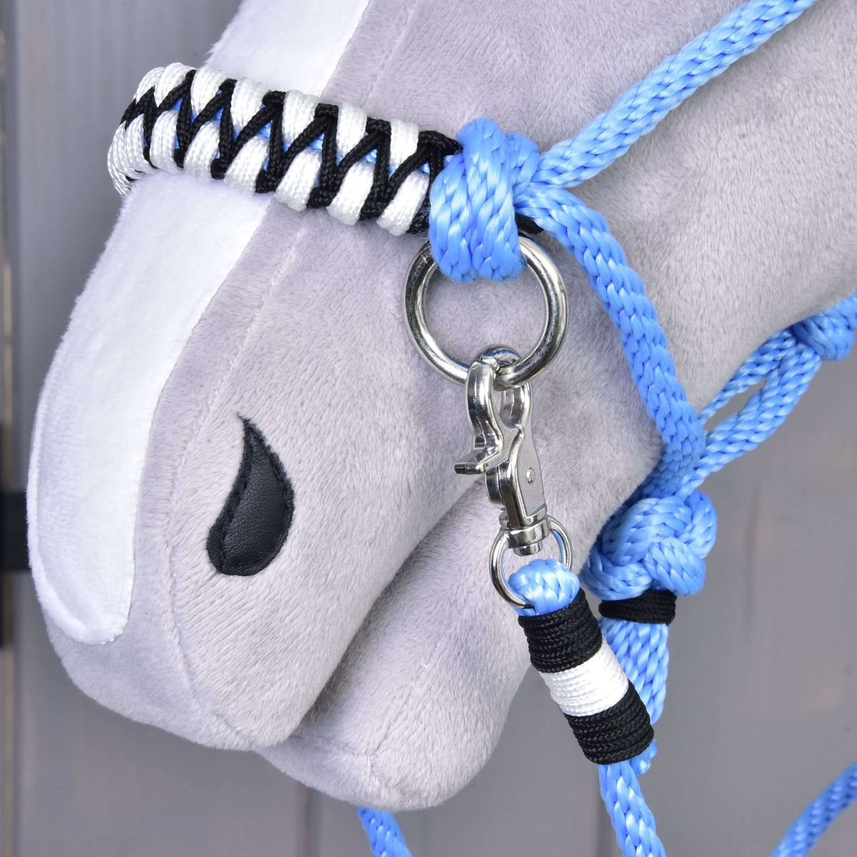 Close-up of the black and white braided noseband, snap hook and wrapped rein end of Rope set Malibu on a Hobby Horse
