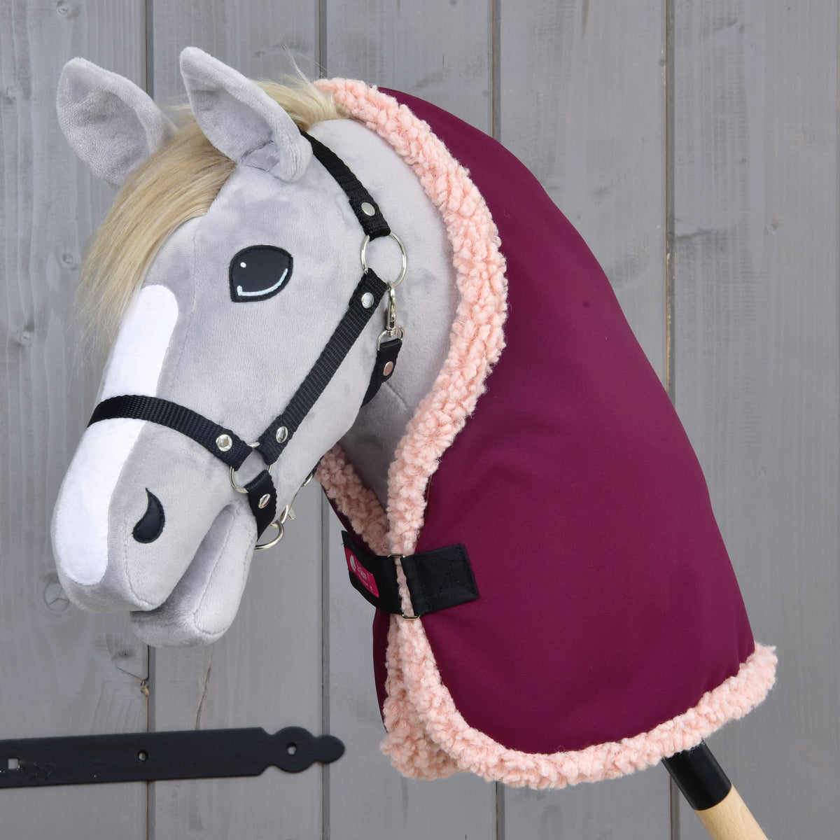 Siv Hobby Horse konj z blond grivo in črno oglavko v hlevskem pregrinjalu Royal Burgundy z bledo roza obrobo iz flisa