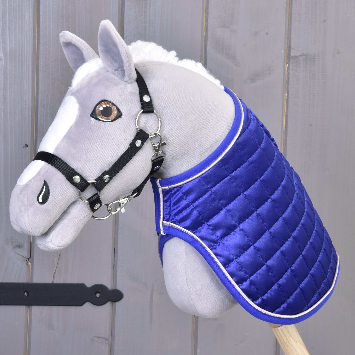 Siv Hobby Horse konj z jantarnimi očmi in črno oglavko nosi pregrinjalo DeLuxe Blue s svetlečo kraljevsko modro stranjo navzven