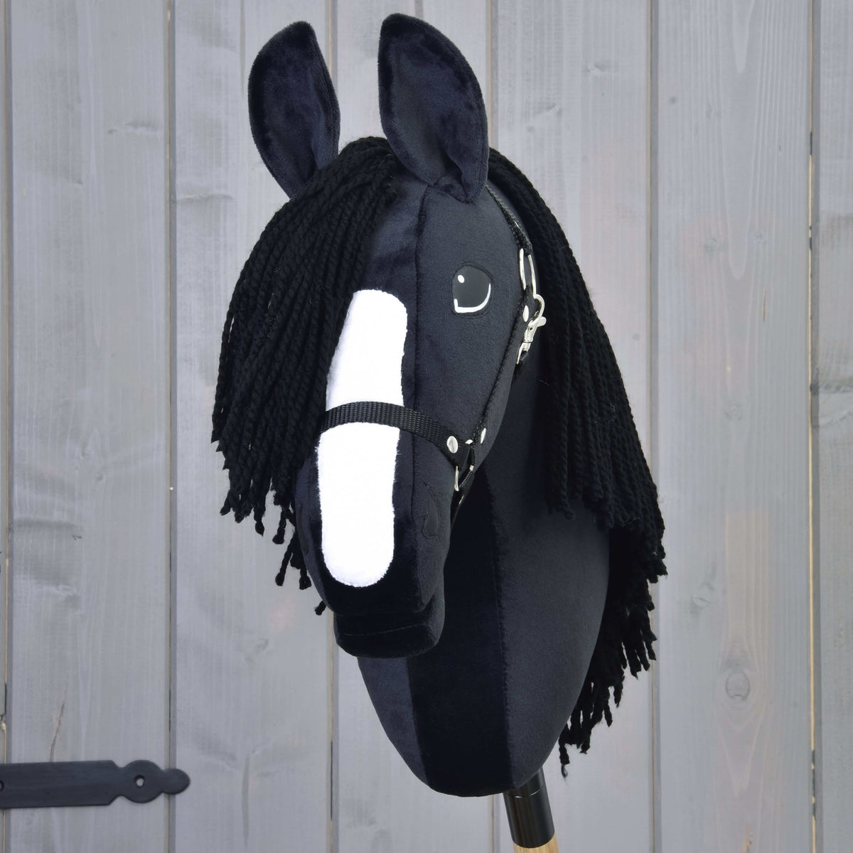 Front view of Hobby Horse Freya with a broad white blaze, black yarn forelock and black halter