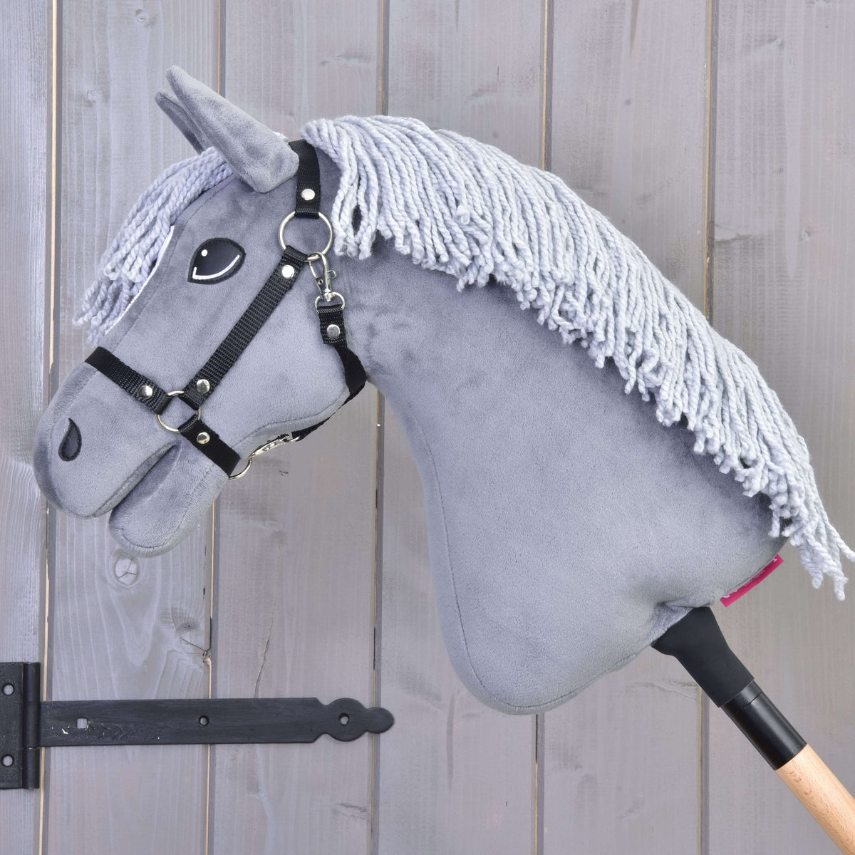 Hobby Horse Grace in left profile with a long pale grey yarn mane falling over the grey neck and a black halter