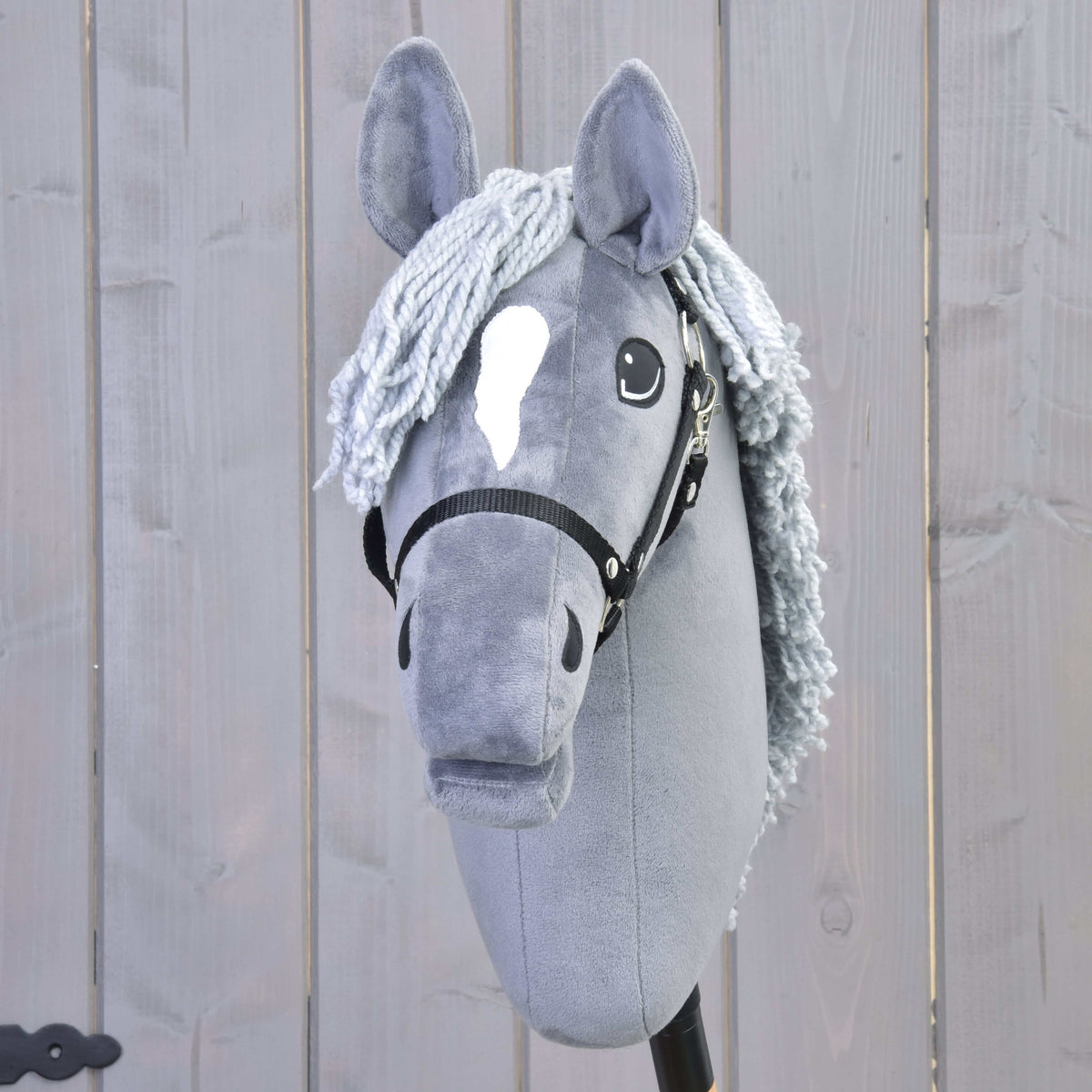 Front view of Hobby Horse Grace with a white star, pale grey yarn forelock and black halter