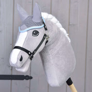 Siv Hobby Horse konj s spleteno belo grivo in črno oglavko nosi kvačkane sive naušnike s svetlo modro obrobo