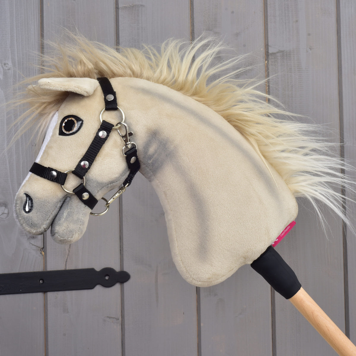 Hobby Horse Ivory Dream in left profile, black halter with silver rivets and blond mane flowing over the cream neck