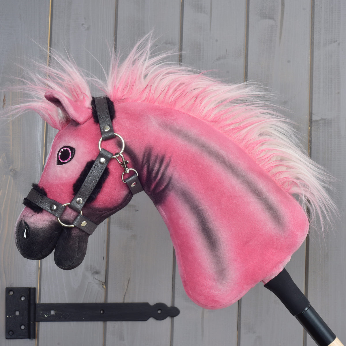 Hobby Horse Pinkie z bleščečo oglavko v levem profilu: roza-bela griva iz umetnega krzna in črne proge na vratu, nanesene z zračnim čopičem