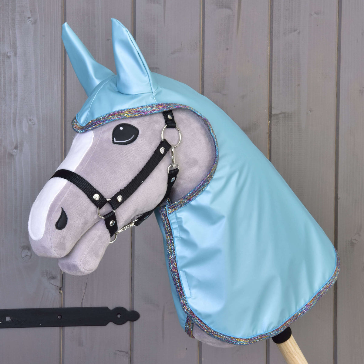 Siv Hobby Horse konj s črno oglavko nosi svetleče dežno pregrinjalo Light Blue z ušesnimi deli in mavrično bleščečo obrobo