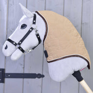 Grey Hobby Horse in a black halter wearing the beige heart-quilted neck cover with brown edging