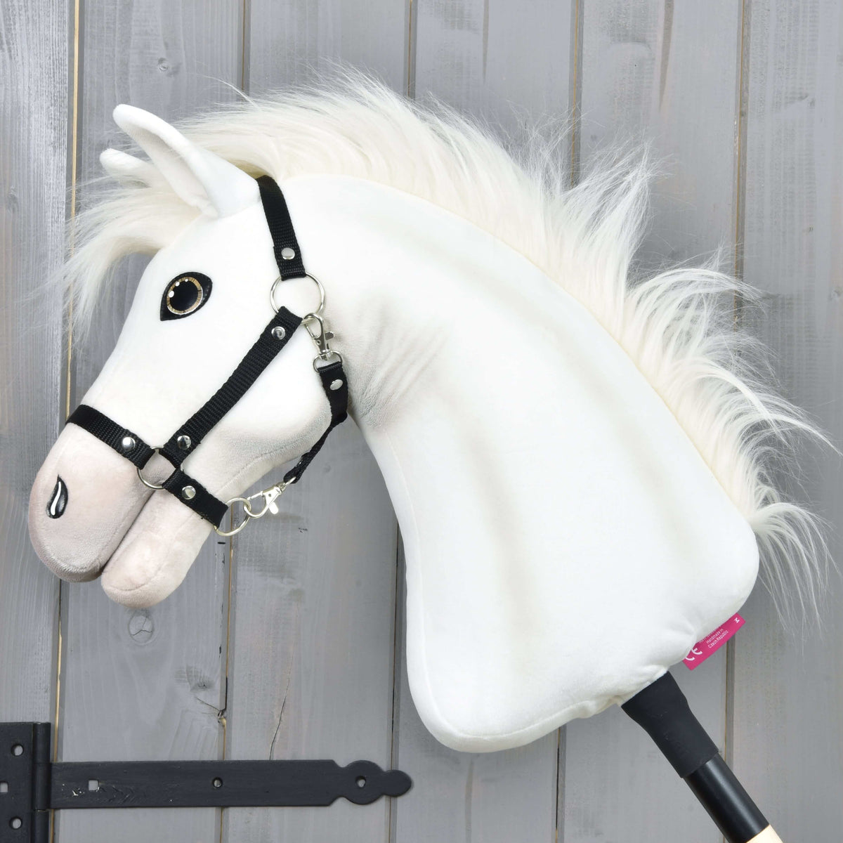 Hobby Horse Nexus in left profile with the long fluffy white mane flowing along the neck and a black halter