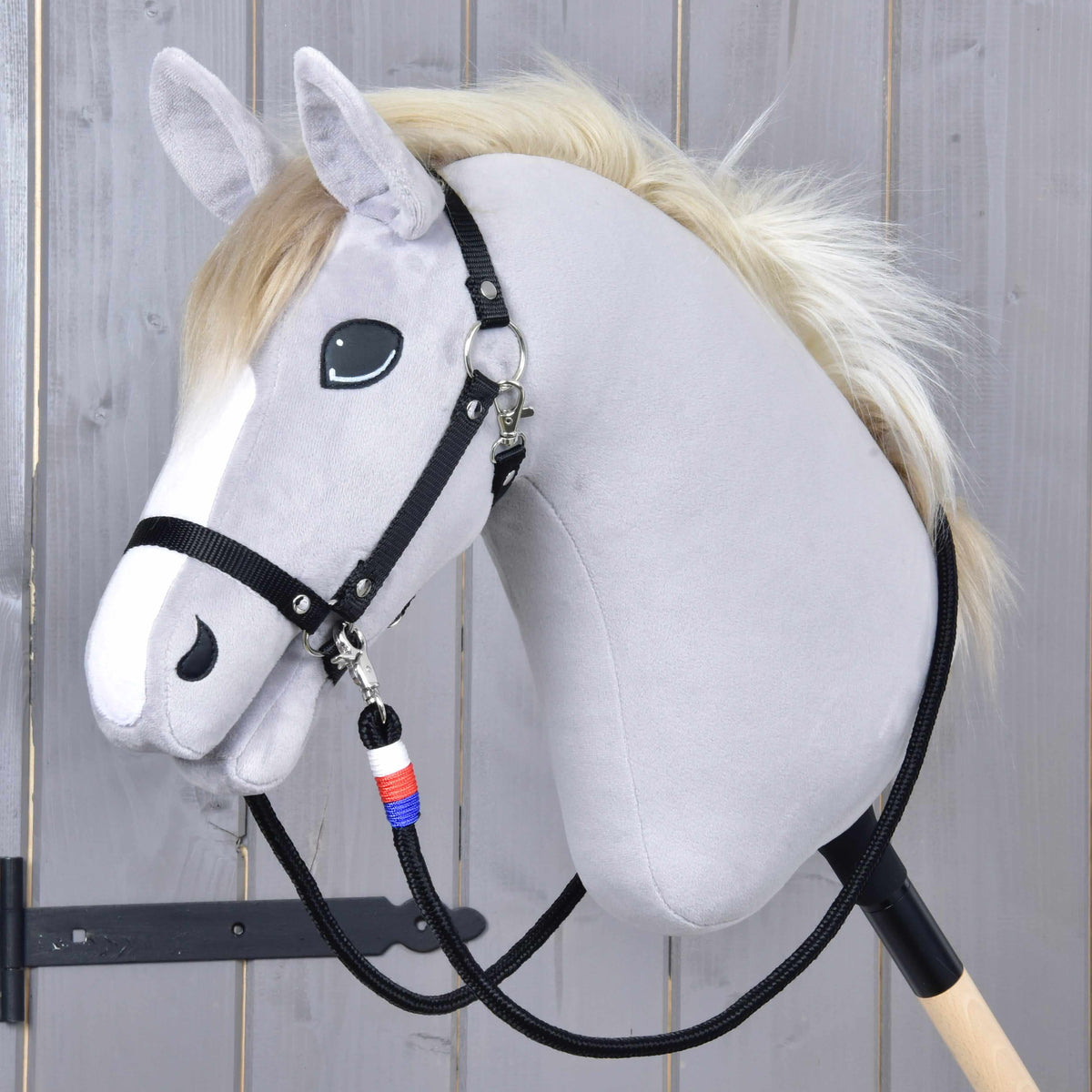 Vajeti Emblem CZ na sivem Hobby Horse konju s smetanasto grivo in črno oglavko, belo-rdeče-moder ovoj pod brado