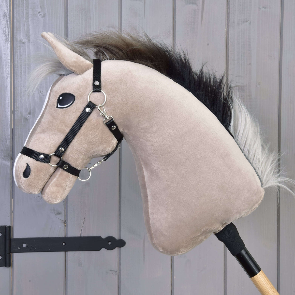 Hobby Horse Piccolino in left profile, showing the greyish beige neck, black halter and the dark mane with silver ends