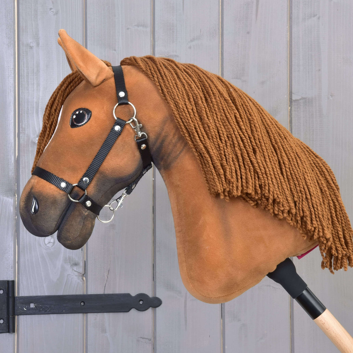 Hobby Horse Pippa in left profile with a long brown yarn mane and a darker shaded muzzle
