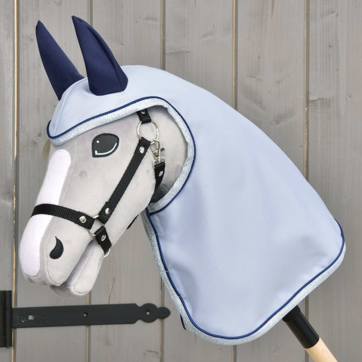 Light grey Hobby Horse with a black halter wearing the light blue Raincoat Luméa with its hood and navy ears