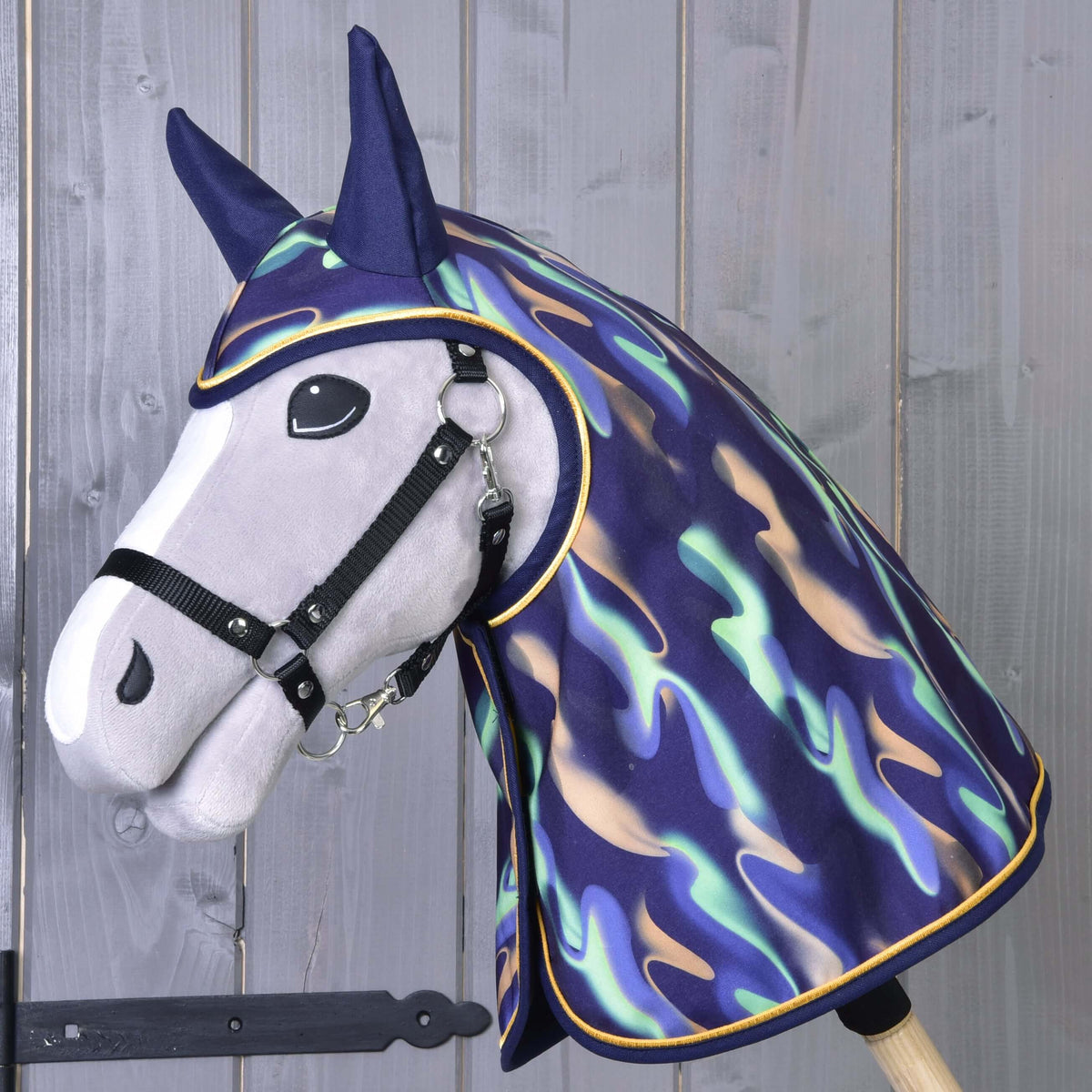 Grey Hobby Horse in a black halter wearing the Raincoat rainbow, which covers the head and neck and has navy ears