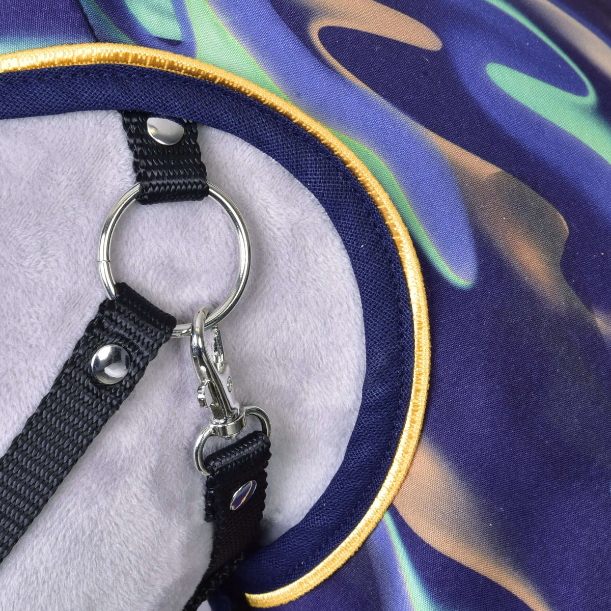 Close-up of a black halter's ring and snap hook against the yellow-piped edge of the Hobby Horse Raincoat rainbow