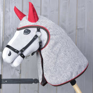 Siv Hobby Horse konj s črno oglavko, oblečen v melirano sivo dežno pregrinjalo z rdečimi prevlekami za ušesa čez glavo in vrat