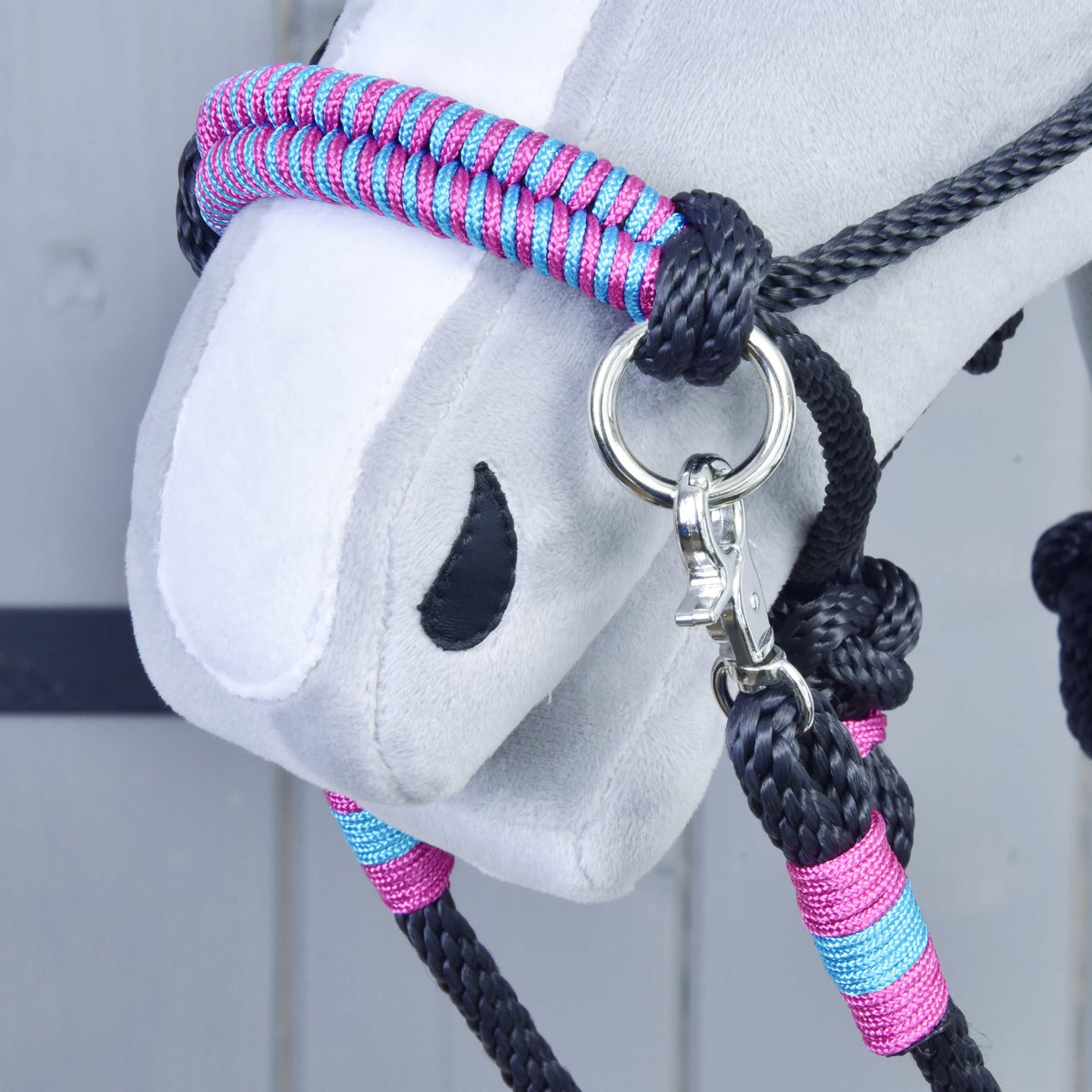 Close-up of the Hobby Horse Rope set Princess noseband braided in pink and turquoise, with a silver ring and snap hook