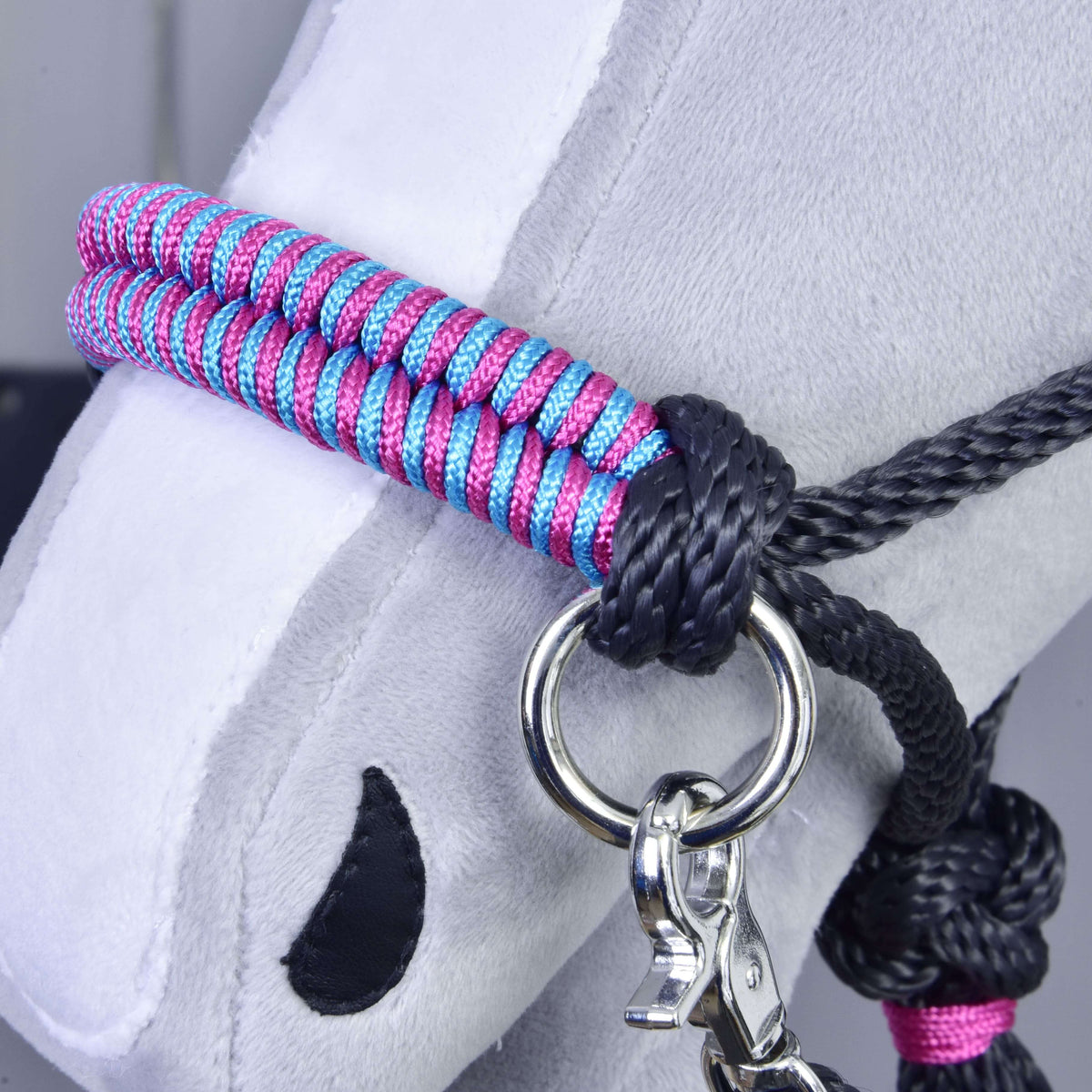 Macro detail of the pink and turquoise braiding and black rope knot on the Hobby Horse Rope set Princess noseband