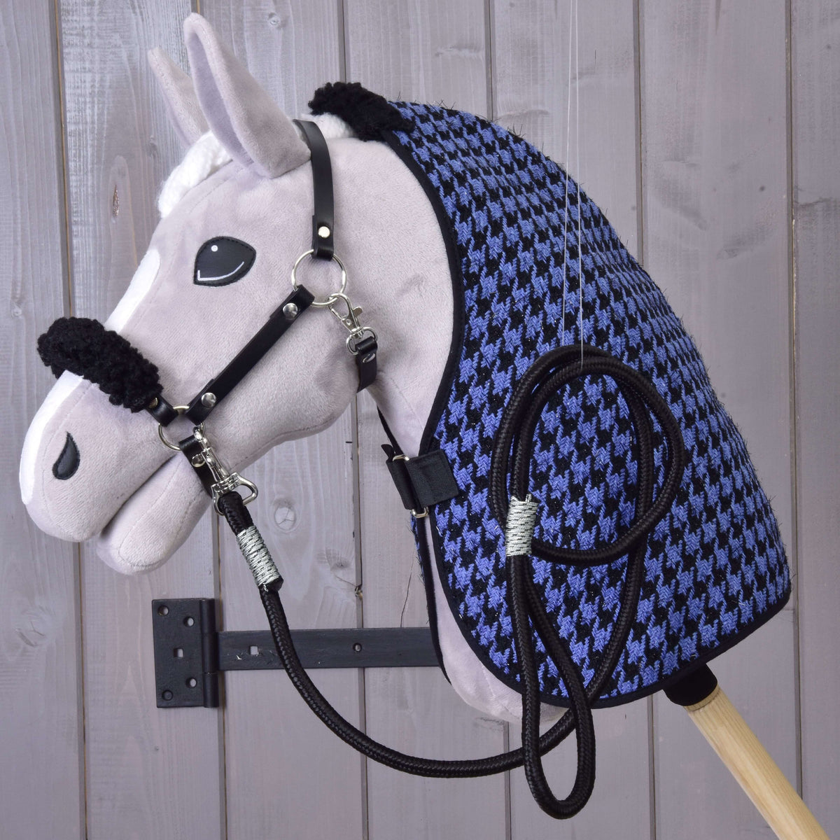 Siv plišast Hobby Horse konj nosi pregrinjalo z vzorcem pepita, črno oglavko s krznom in črn povodec iz kompleta Harmony Blue