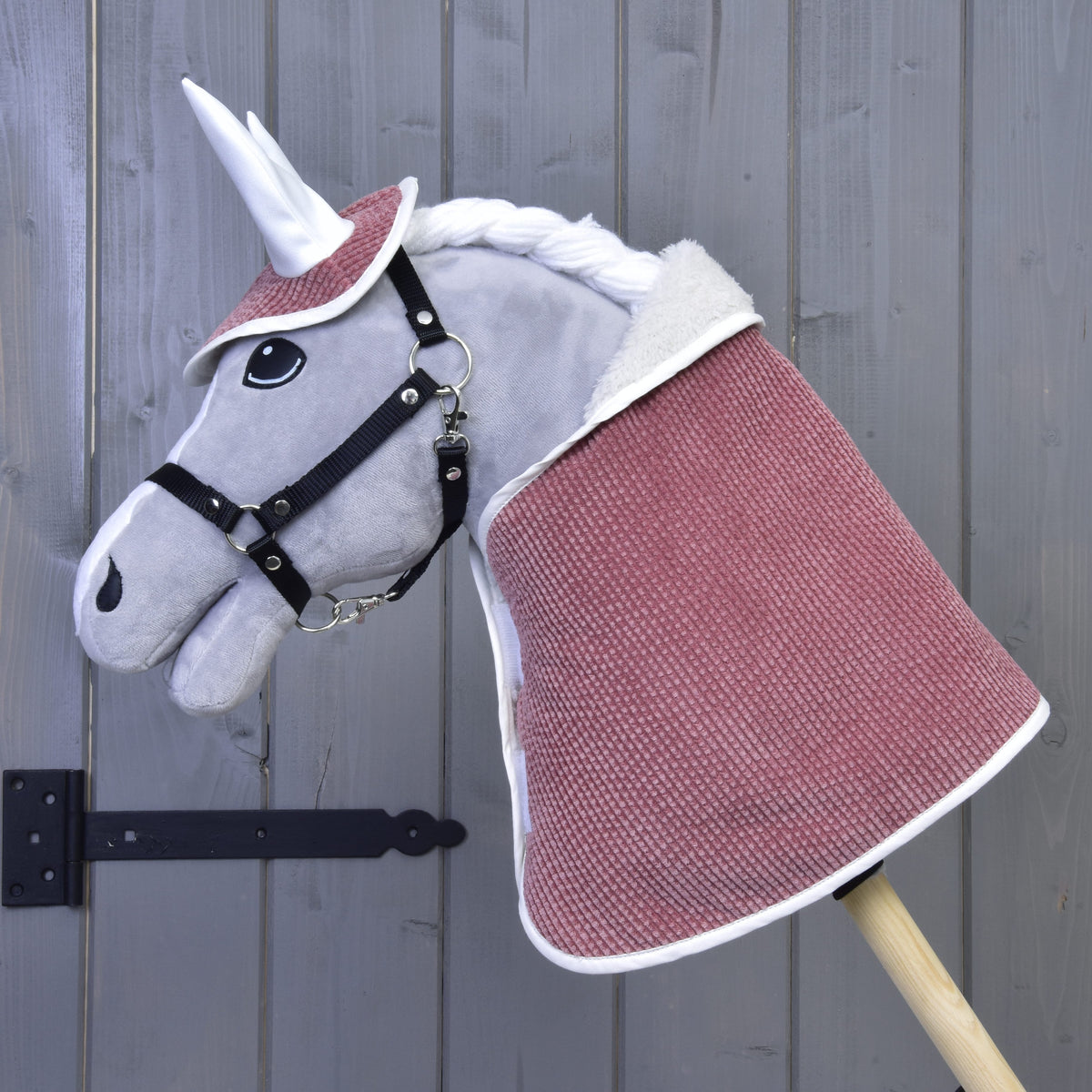 Siv plišast Hobby Horse konj s črno oglavko nosi pudrasto roza pregrinjalo in naušnike iz kompleta Manchester Tea Rose
