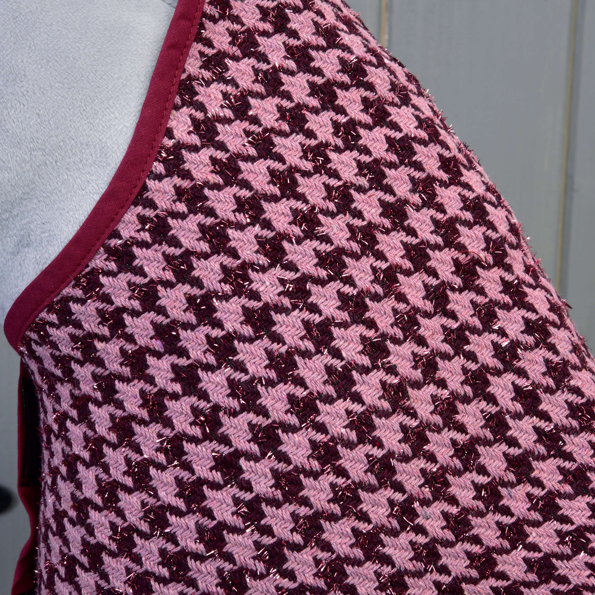 Close-up of the houndstooth blanket fabric in pink and burgundy with sparkly thread and burgundy binding