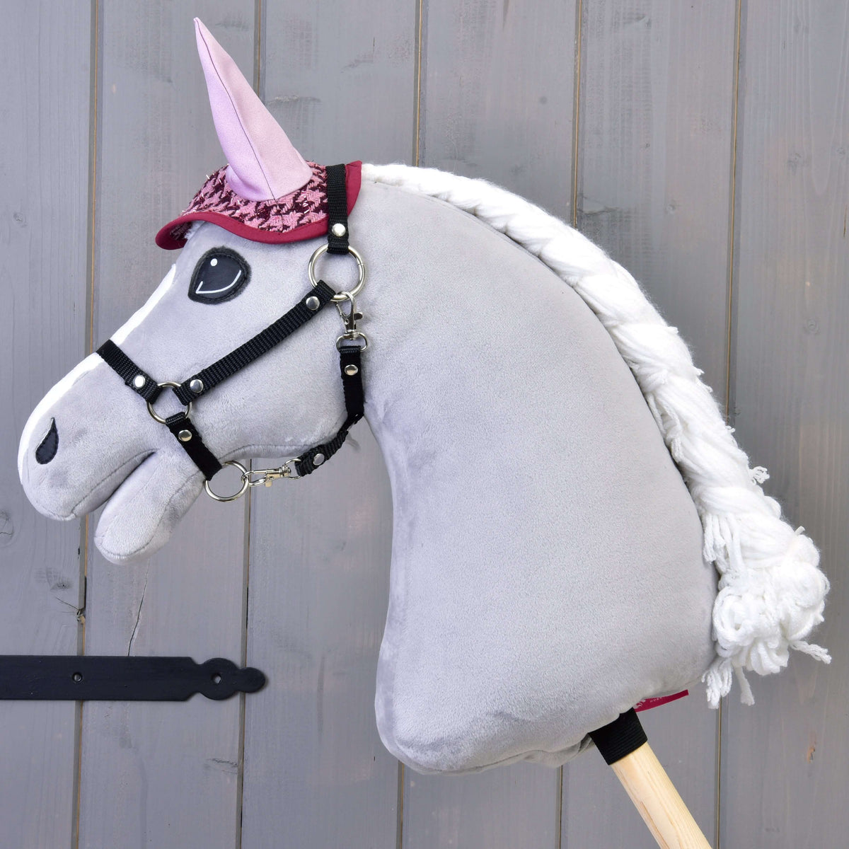 Grey Hobby Horse with a braided white mane wearing only the houndstooth ear bonnet with light pink ears