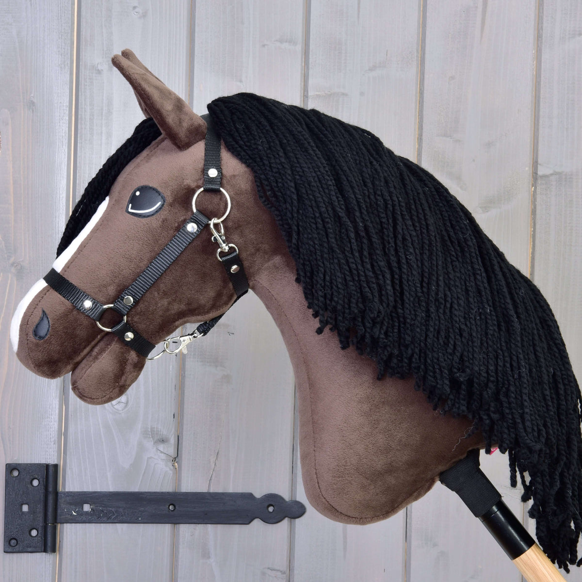 Hobby Horse Sisi in left profile with a thick black yarn mane over the dark brown neck and a black halter