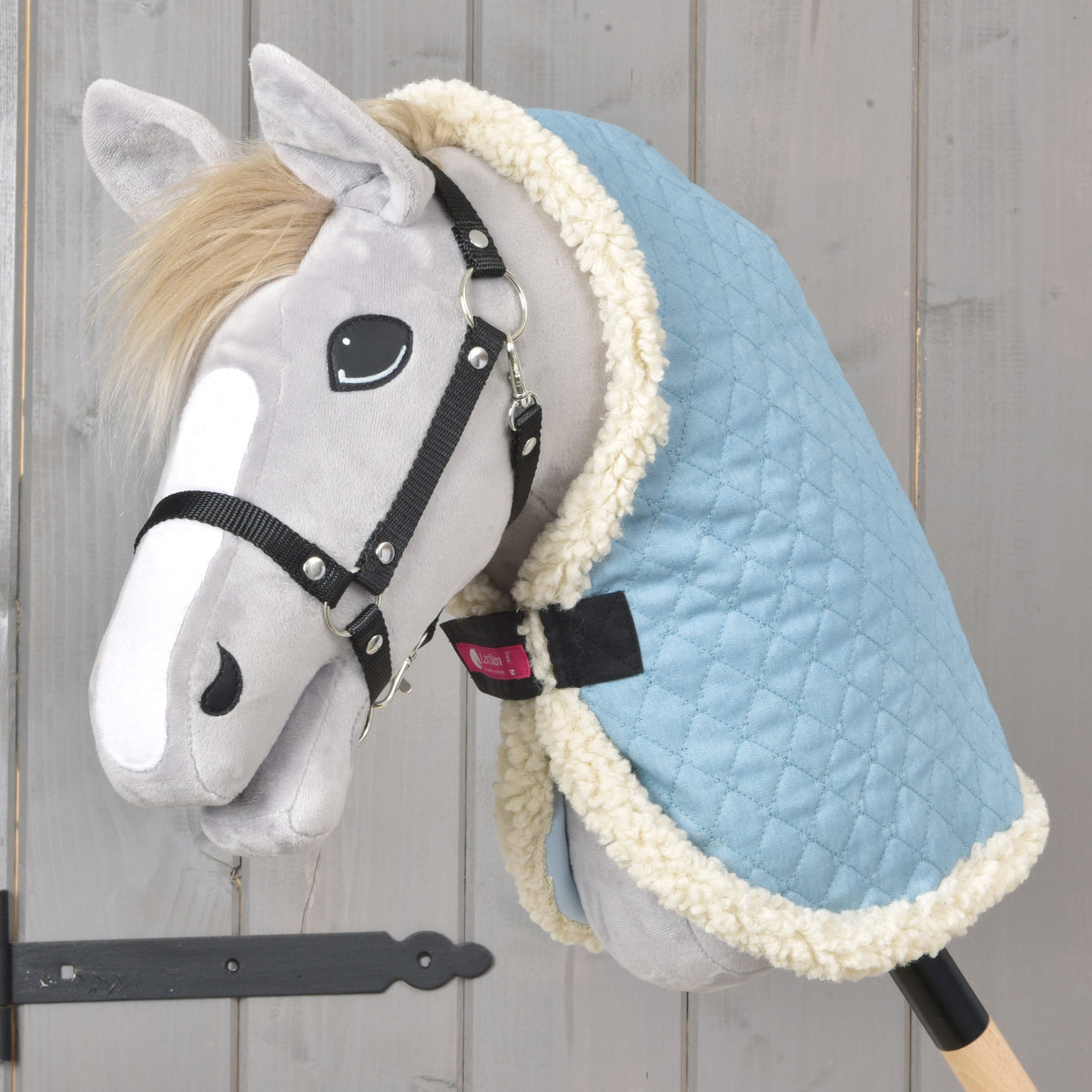 Grey Hobby Horse in a black halter wearing the light blue quilted Stable Blanket Sky Blue with cream fleece edging