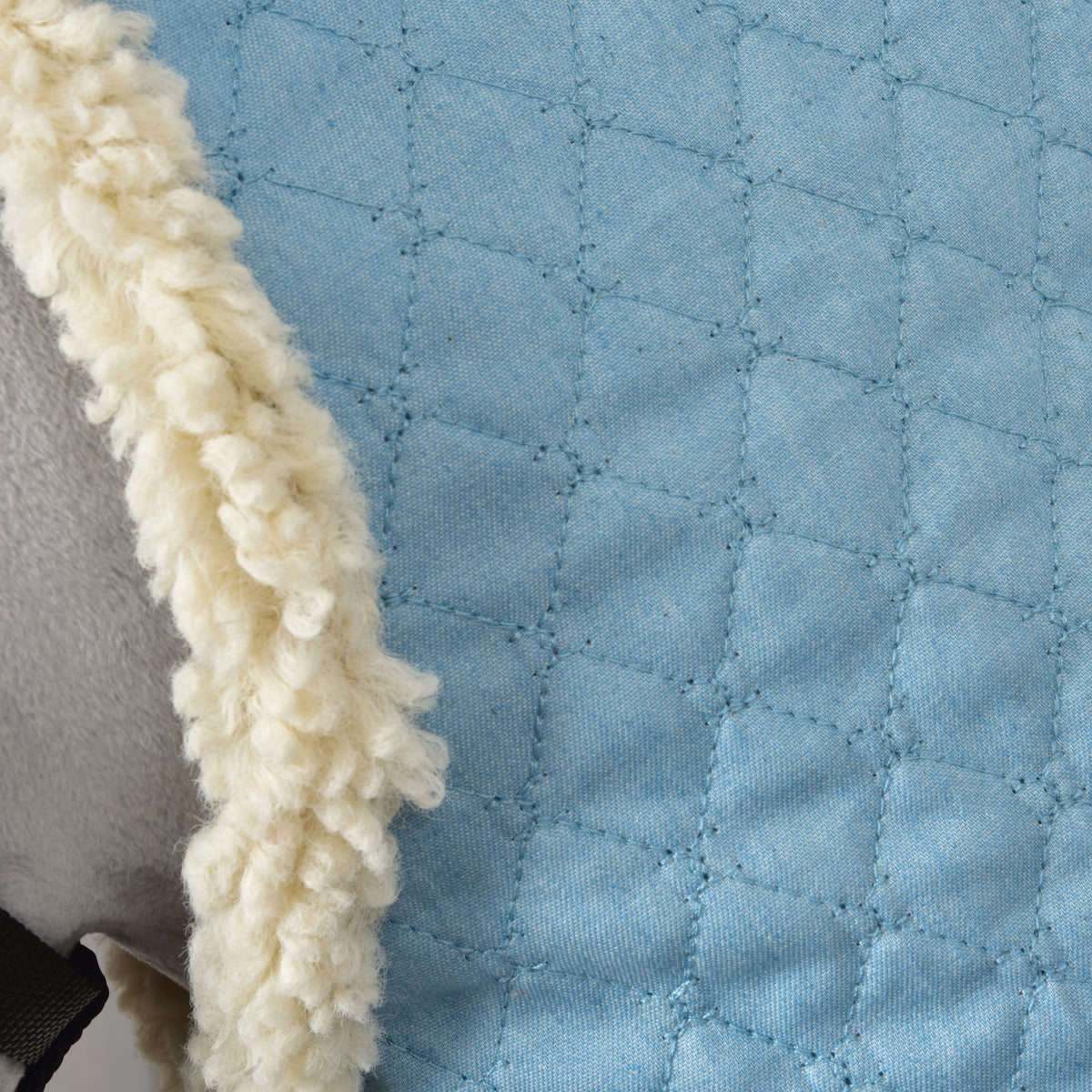 Close-up of the Hobby Horse Stable Blanket Sky Blue showing diamond quilting stitches and fluffy cream fleece trim