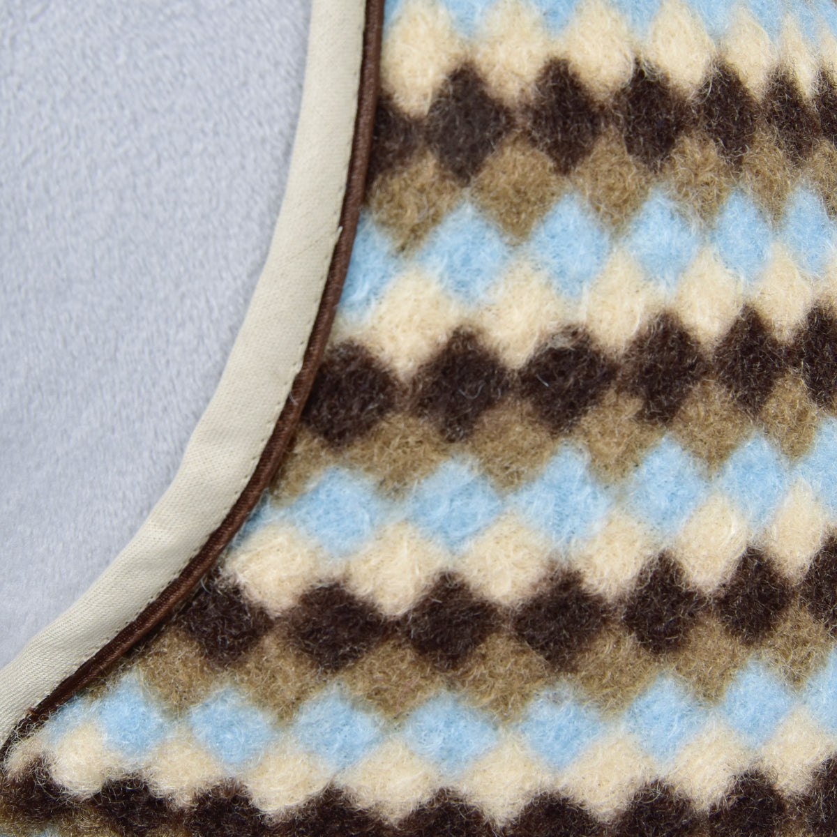 Macro of the brown, taupe, cream and light blue diamond fleece and beige binding of the Hobby Horse Stable Blanket Pastel Argyle