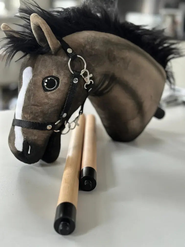 Brown Hobby Horse head with a black mane, white blaze and black halter beside a two-part wooden stick with black caps