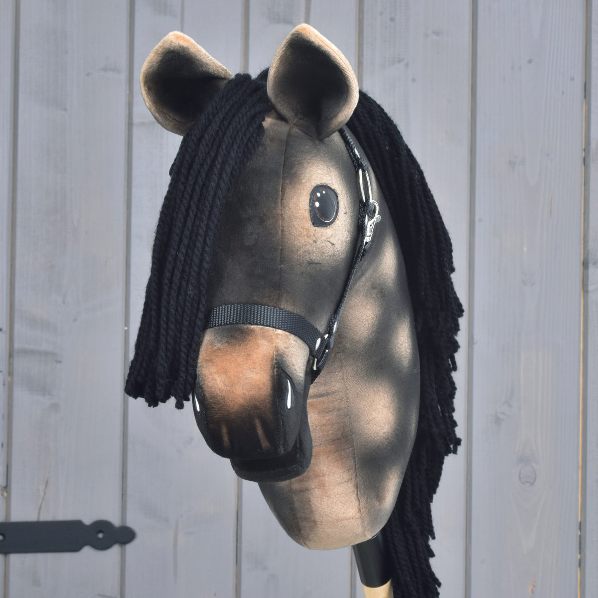 Hobby Horse Stormy s črno oglavko od spredaj: črn čop iz preje, svetlo rjav gobec in rjava ušesa s svetlim robom